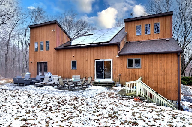 snow covered property featuring solar panels