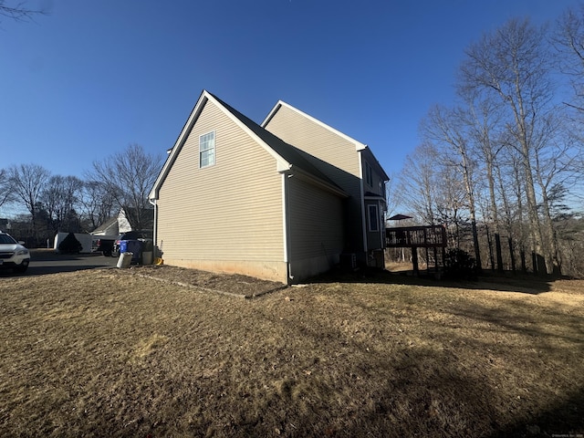 view of side of property featuring a wooden deck and a yard