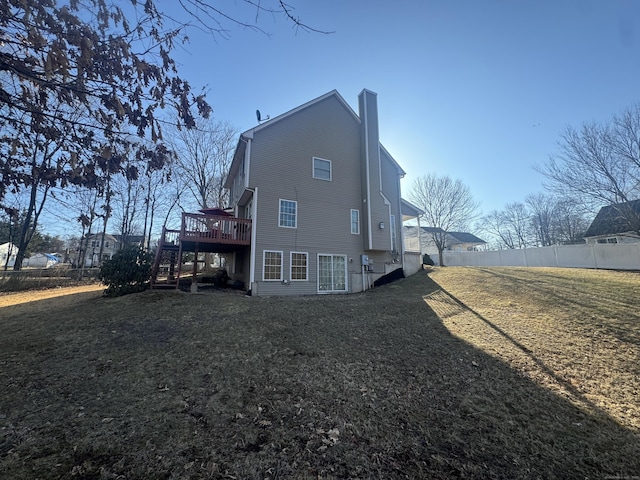 back of house with fence, a yard, stairway, a wooden deck, and a chimney