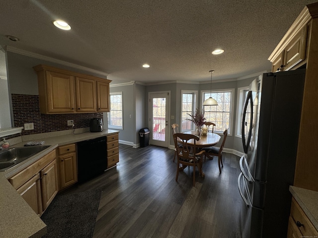 kitchen with dark wood-style floors, freestanding refrigerator, a sink, dishwasher, and crown molding