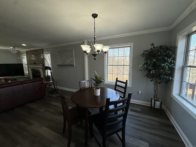 dining space with a textured ceiling, a chandelier, dark wood finished floors, and crown molding