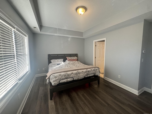 bedroom featuring visible vents, baseboards, and wood finished floors