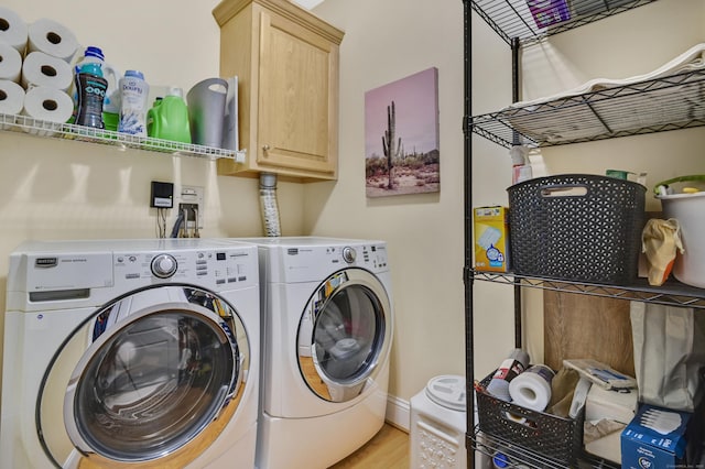 washroom with washing machine and dryer and cabinets