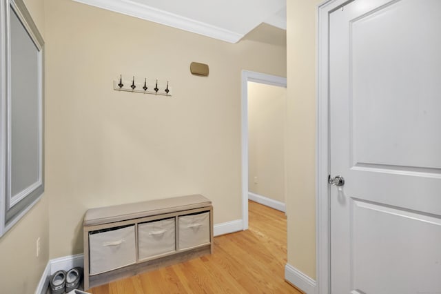 hall with light hardwood / wood-style flooring and ornamental molding