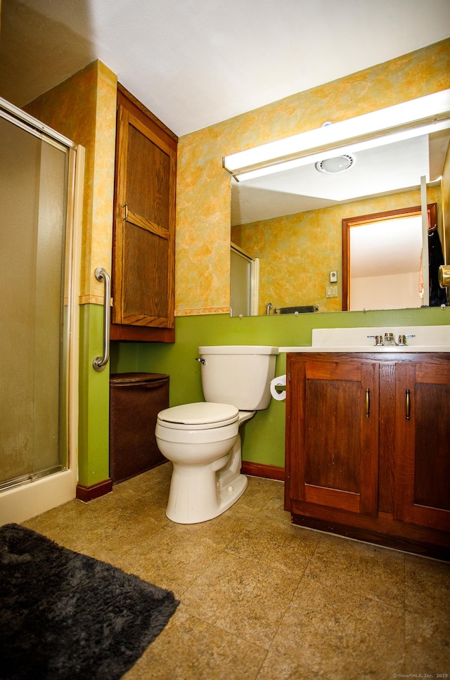 bathroom featuring vanity, toilet, and an enclosed shower