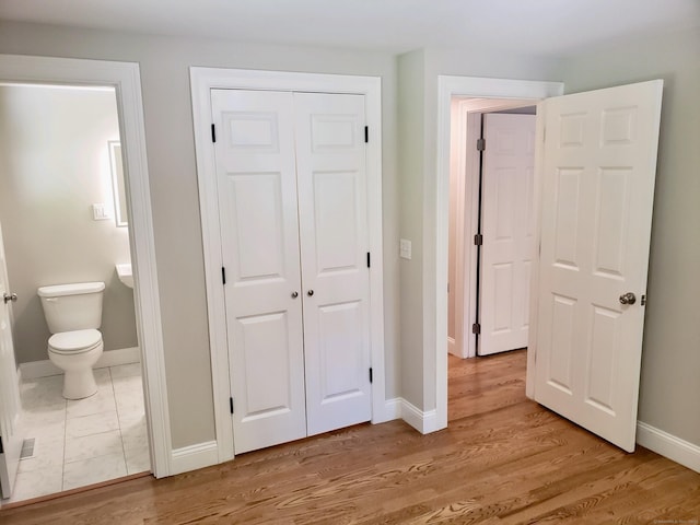 interior space featuring hardwood / wood-style floors, ensuite bath, and a closet