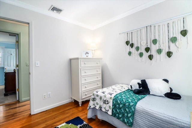 bedroom with crown molding and wood-type flooring