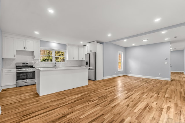 kitchen with white cabinetry, stainless steel appliances, sink, and backsplash