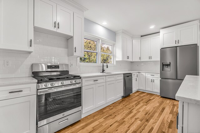 kitchen featuring appliances with stainless steel finishes, sink, and white cabinets