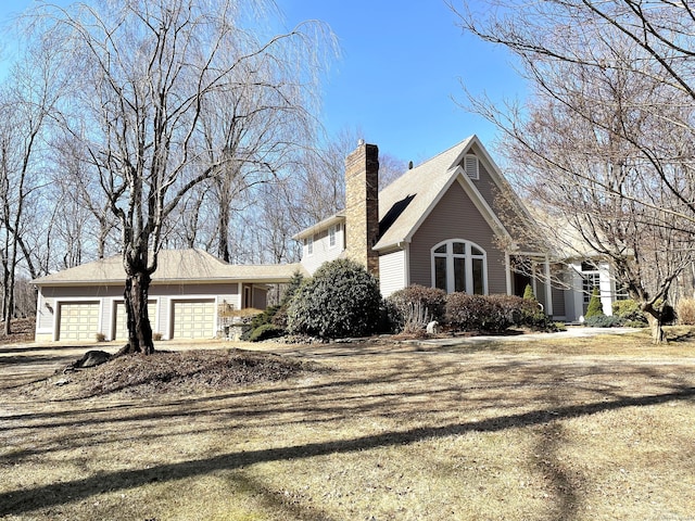 view of front facade featuring a garage and a chimney