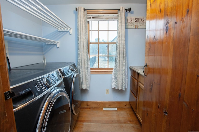 laundry area featuring wood-type flooring and separate washer and dryer