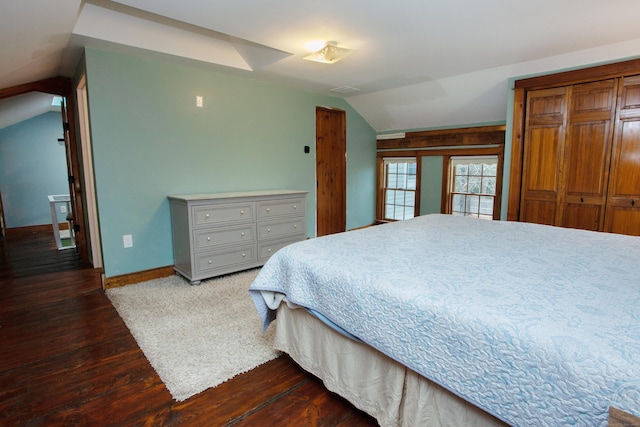 bedroom with vaulted ceiling and dark hardwood / wood-style floors