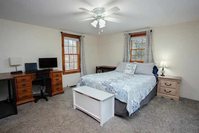 carpeted bedroom featuring multiple windows and ceiling fan