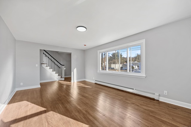 spare room featuring wood-type flooring and a baseboard heating unit