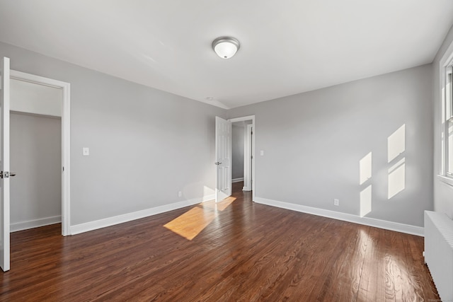 empty room featuring dark hardwood / wood-style floors and radiator