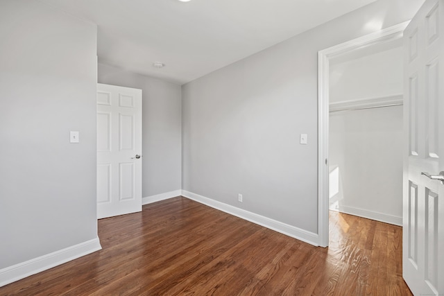 unfurnished bedroom featuring dark hardwood / wood-style floors and a closet