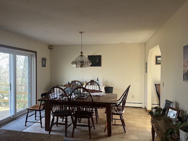 dining space with baseboard heating and a textured ceiling