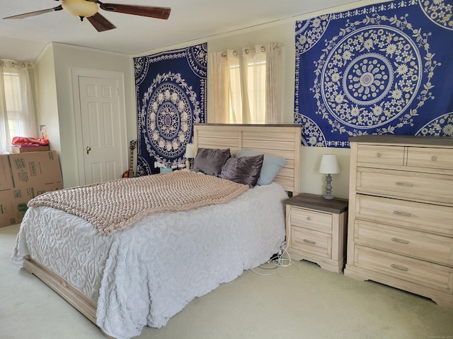 bedroom with multiple windows, light colored carpet, and ceiling fan