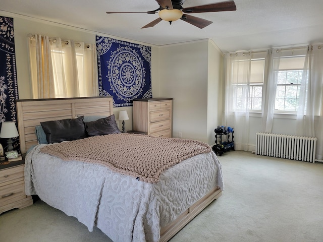 carpeted bedroom featuring radiator, crown molding, and ceiling fan