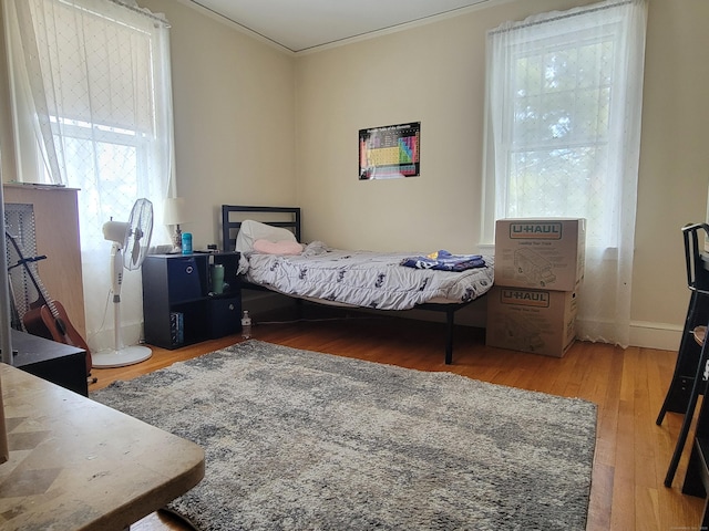 bedroom featuring ornamental molding and hardwood / wood-style floors