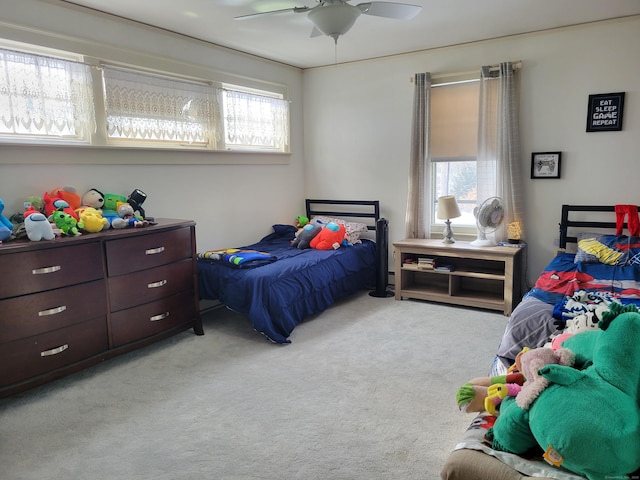 carpeted bedroom featuring multiple windows and ceiling fan