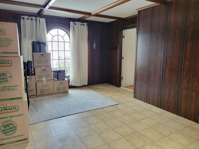 entryway with coffered ceiling, beam ceiling, and wood walls