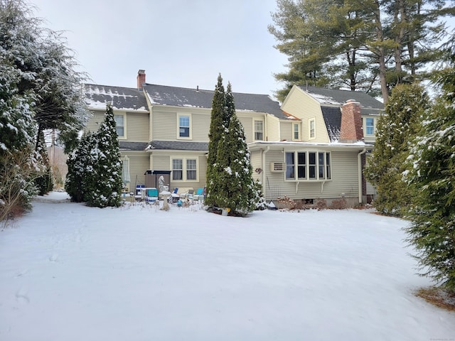 view of snow covered back of property