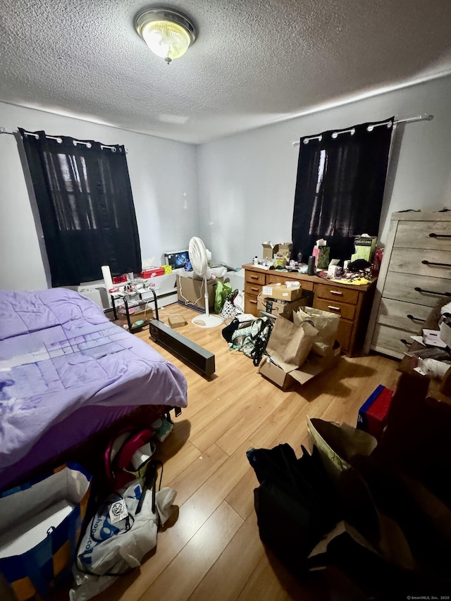 bedroom with a textured ceiling and light wood-type flooring