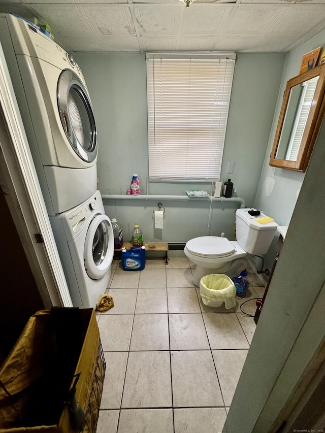 laundry room featuring tile patterned flooring and stacked washer / dryer