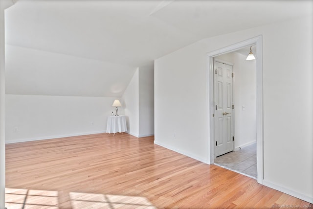 additional living space with lofted ceiling and light wood-type flooring