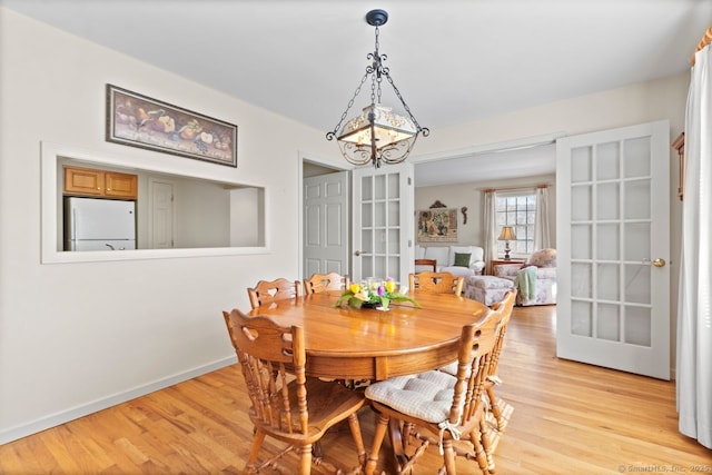 dining area featuring an inviting chandelier and light wood-type flooring