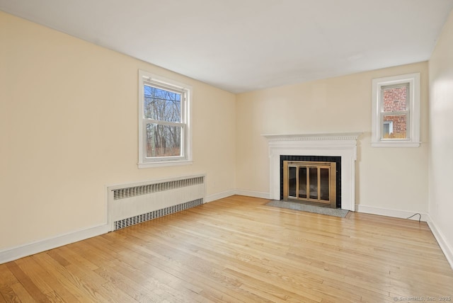 unfurnished living room featuring radiator and light hardwood / wood-style floors