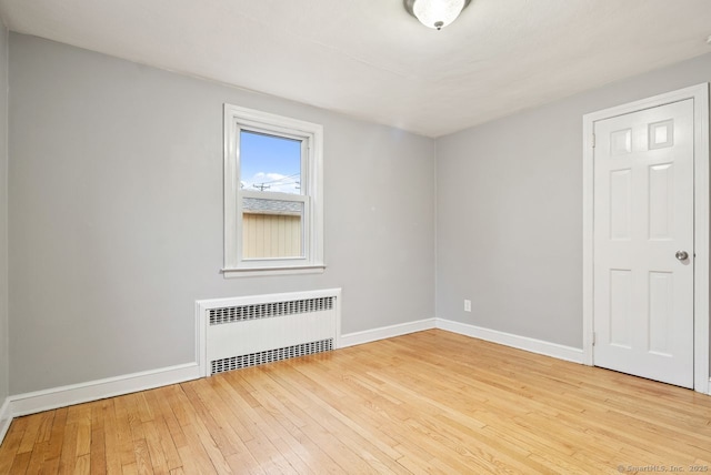 unfurnished room with radiator and light hardwood / wood-style floors