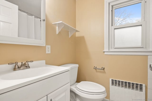 bathroom featuring vanity, toilet, and radiator