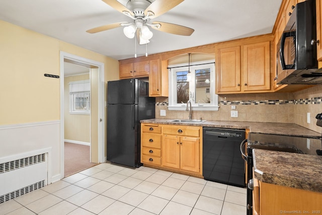 kitchen featuring sink, black appliances, radiator heating unit, ceiling fan, and backsplash