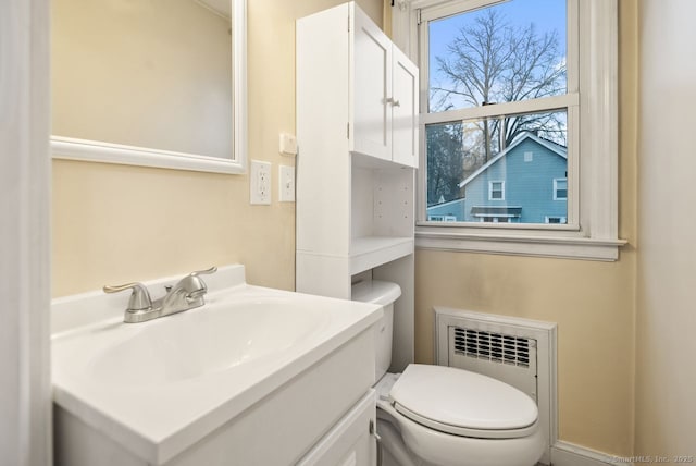 bathroom featuring vanity, toilet, and radiator