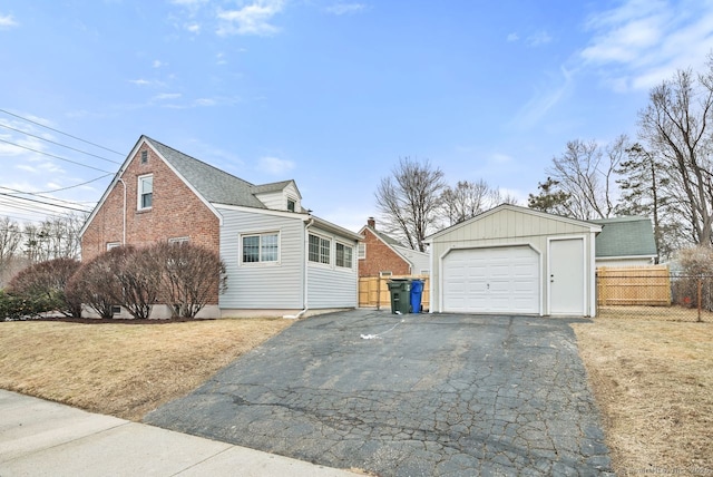 view of front of house featuring a garage, an outdoor structure, and a front yard