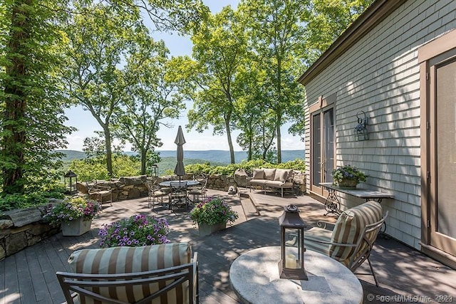 view of patio featuring an outdoor hangout area and a deck with mountain view