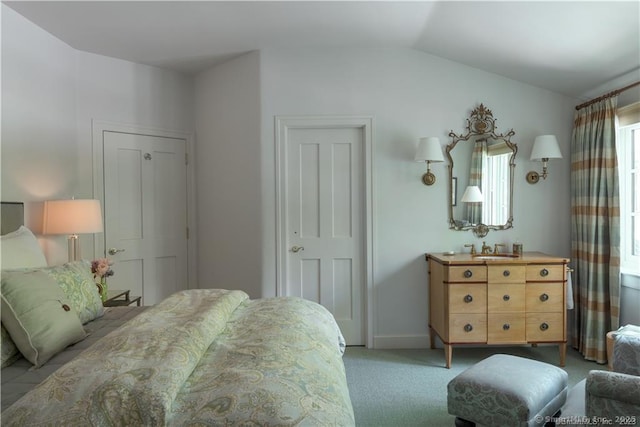 carpeted bedroom with lofted ceiling