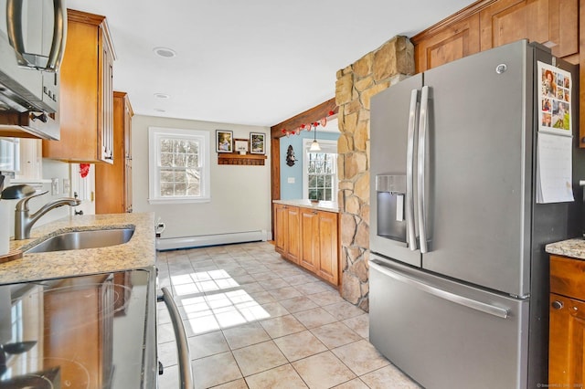 kitchen with light tile patterned flooring, a baseboard radiator, sink, stainless steel fridge, and range