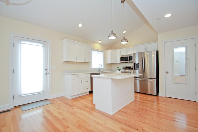 kitchen featuring pendant lighting, white cabinetry, stainless steel appliances, and a center island