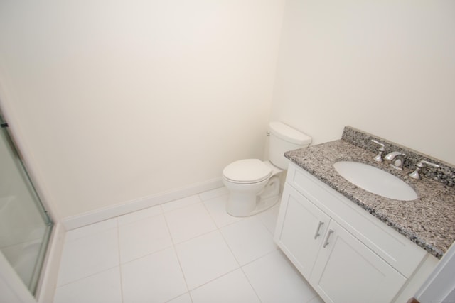 bathroom with vanity, toilet, a shower with shower door, and tile patterned flooring