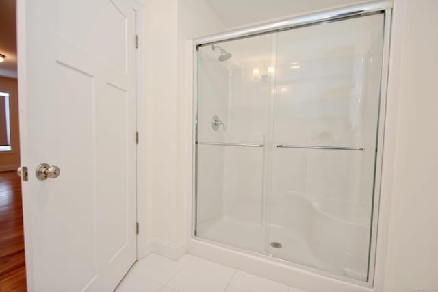 bathroom featuring tile patterned floors and a shower with shower door