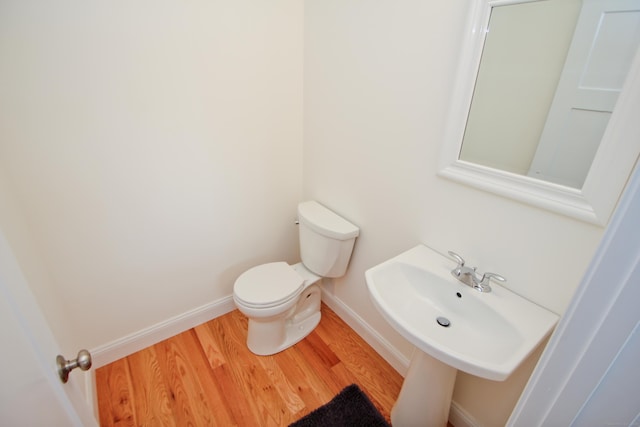 bathroom with hardwood / wood-style floors, sink, and toilet