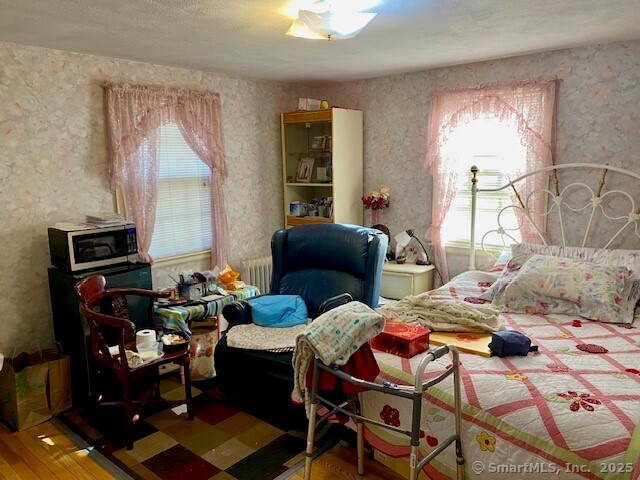 bedroom featuring hardwood / wood-style floors and radiator heating unit