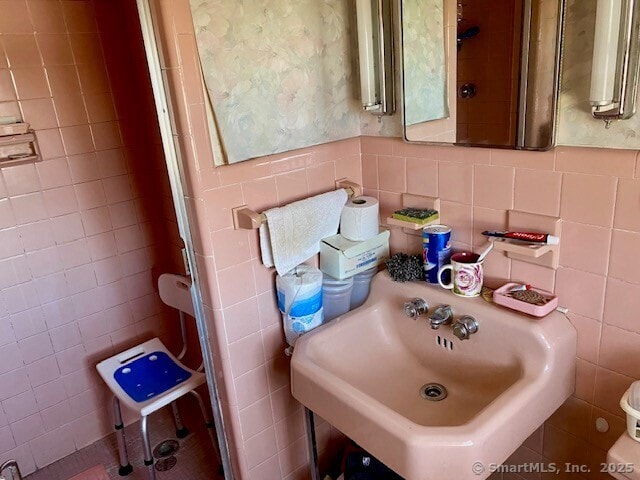 bathroom with tile walls and sink