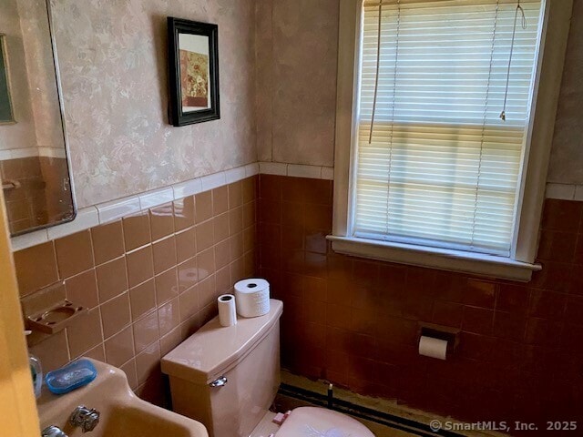 bathroom with tile walls and toilet