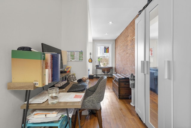 office area featuring brick wall and light wood-type flooring