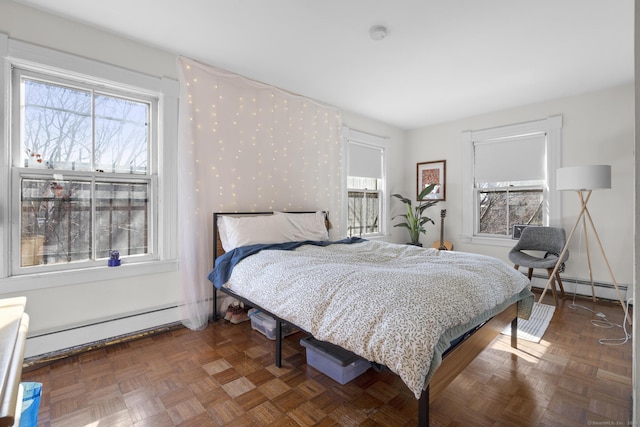 bedroom with multiple windows, a baseboard radiator, and dark parquet floors