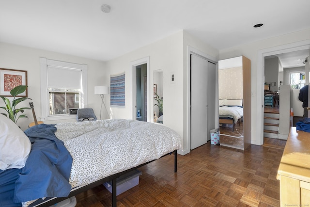 bedroom featuring dark parquet floors and a closet